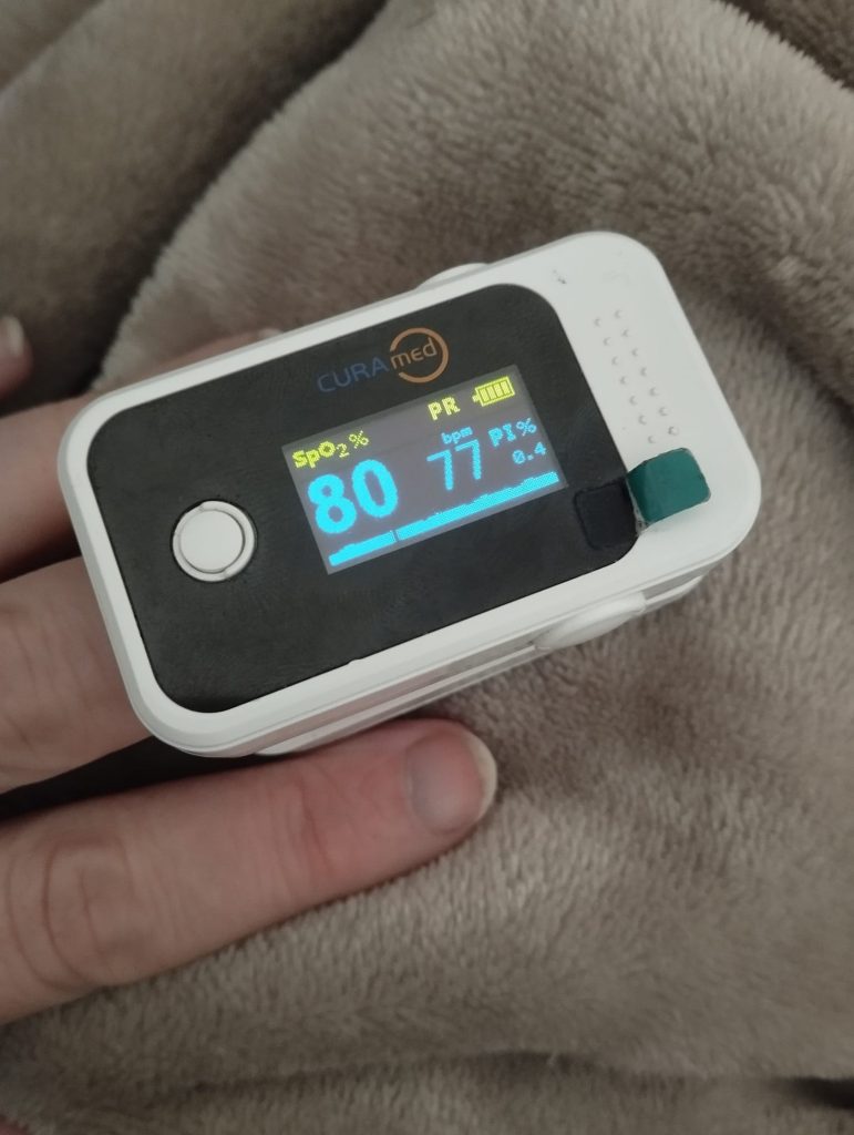 Finger mit Pulsoxymeter mit der Sauerstoffsättigung 80