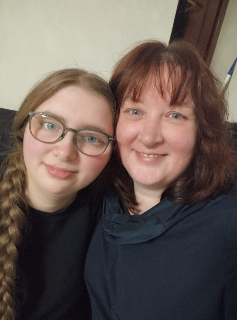 Mutter und erwachsene Tochter nebeneinander auf der Couch